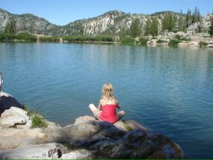 child meditating by lake - wholesome living